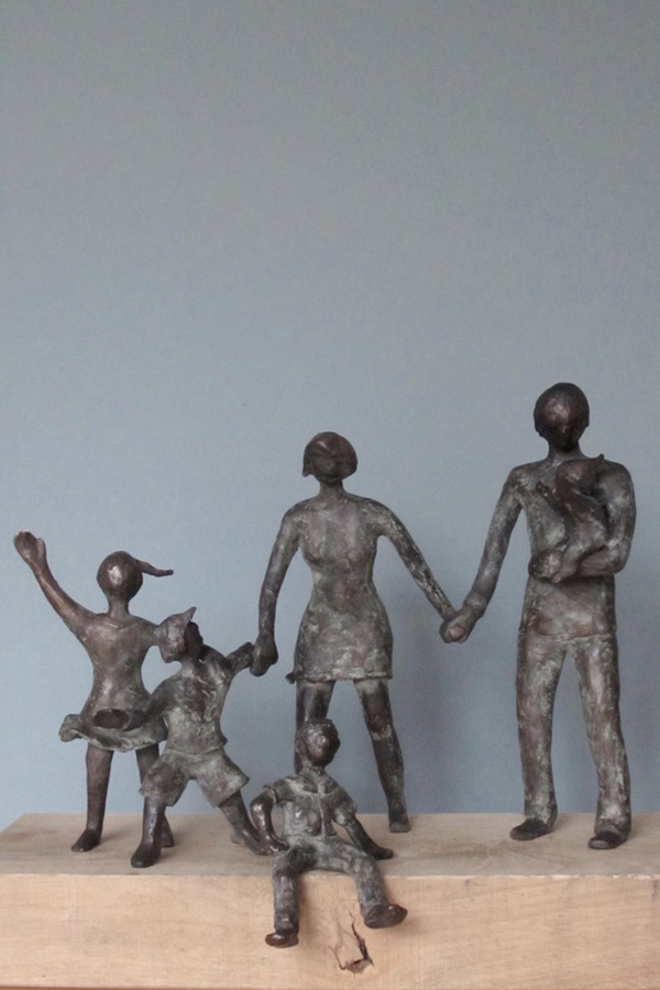 Een familie in brons, man en vrouw hand in hand met kinderen, een baby, zittend jongetje