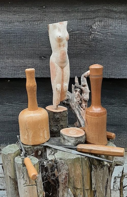 foto van houten beeldje met daarbij gutsen, beitels en een klopper